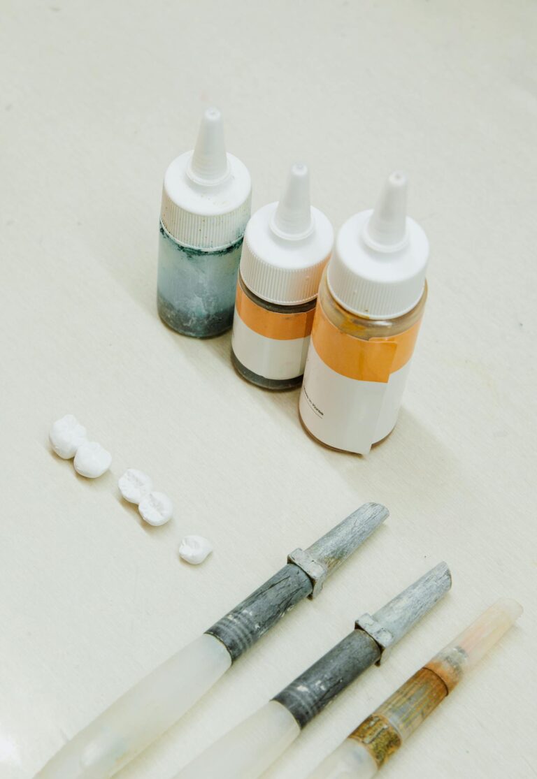 A high-angle view of dental laboratory tools and materials on a clean white surface.